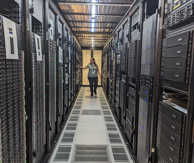 RCC's Sarah Walters checking UQ hardware at the Polaris Data Centre in Springfield, Queensland, including HPC Bunya's racks. (Photo by Ashley Wright, RCC.)