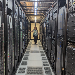 RCC's Sarah Walters checking UQ hardware at the Polaris Data Centre in Springfield, Queensland, including HPC Bunya's racks. (Photo by Ashley Wright, RCC.)