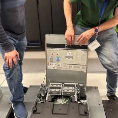 RCC's Aaron McDowall and Owen Powell inspecting the Bunya Phase 3 liquid-cooled GPUs before installation. (Photo: Sarah Walters, RCC.).